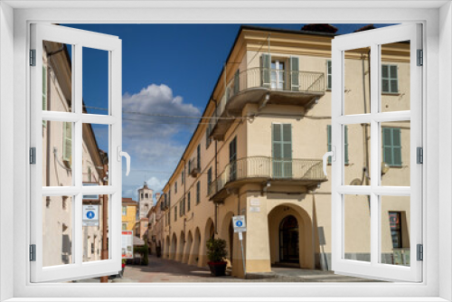 Fototapeta Naklejka Na Ścianę Okno 3D - Fossano, Cuneo, Italy - August 25, 2022: the historic center with via Cavour, pedestrian street with arcades and the civic bell tower at the bottom, blue sky with clouds