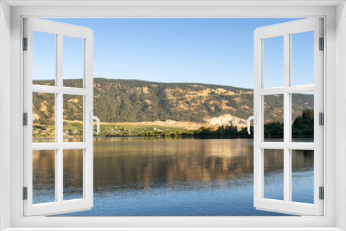 Fototapeta Naklejka Na Ścianę Okno 3D - Peaceful View of Wood Lake with Reflection on the water and mountains in background. Lake Country, Okanagan, British Columbia, Canada. Sunrise