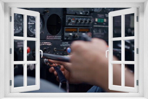 Pilot starting airplane engine using key sitting in modern plane cabin closeup.