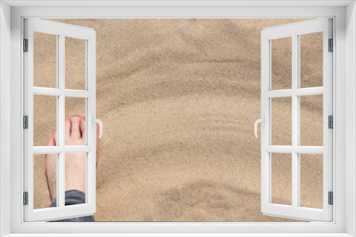 Fototapeta Naklejka Na Ścianę Okno 3D - a woman's foot on the sand with a copy of the space