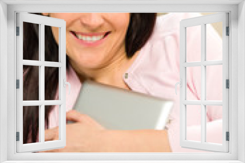 Smiling woman embracing her digital tablet