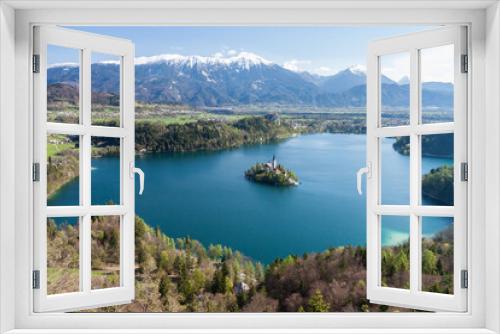 Fototapeta Naklejka Na Ścianę Okno 3D - Scenic, high elevation view of famous Lake Bled in Slovenia, with snowy Julian Alps mountain range in the background, spring growth on the trees and an island with a historical church.