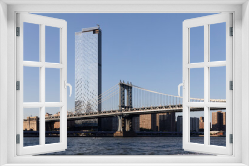 Fototapeta Naklejka Na Ścianę Okno 3D - Skyscraper building towering over Manhattan Bridge