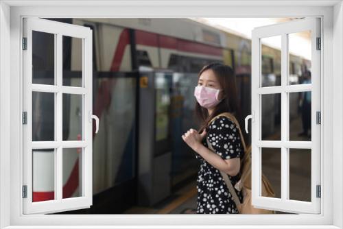 Young asian womanusing smartphone while waiting for subway or sky train.