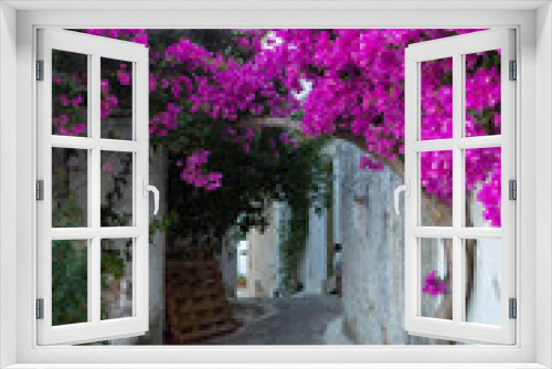 Fototapeta Naklejka Na Ścianę Okno 3D - Narrow and colorful street in the village of Kritsa in the island of Crete. White street, beautiful traditional housing in Greece. 
