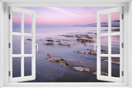 Fototapeta Naklejka Na Ścianę Okno 3D - Purple lilac morning blue hour sky and September full moon setting during low tide at Birling Gap and the Seven sisters on the east Sussex coast south east England UK