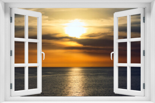 Fototapeta Naklejka Na Ścianę Okno 3D - Stunning warm sunset in a dramatic sky above a serene, calm ocean