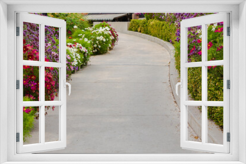 Fototapeta Naklejka Na Ścianę Okno 3D - Walkway in flower garden in summer time. View of Colourful Flowerbeds in a good care maintenance landscapes and walkway