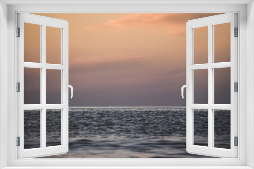 Water ripples on the surface of the Black Sea and the horizon of the sea and sky in soft twilight lighting after sunset