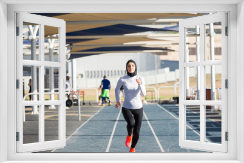 Arabian woman with typical muslim dress training outdoors in Dubai - Middle-eastern beautiful female adult doing fitness outside