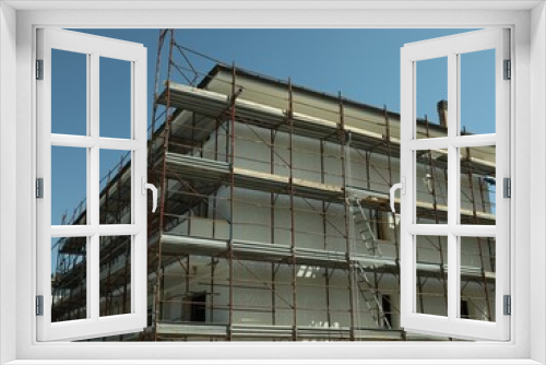 Fototapeta Naklejka Na Ścianę Okno 3D - Unfinished building with scaffolding outdoors on sunny day