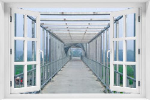 Fototapeta Naklejka Na Ścianę Okno 3D - The unique interior of the over bridge. Beautiful foot over bridge pathway at morning unique blurry photo. Steel bridge.