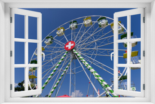 Fototapeta Naklejka Na Ścianę Okno 3D - Ferris wheel with Swiss flag at village of Ascona, Canton Ticino, on a sunny summer day. Photo taken July 24th, 2022, Ascona, Switzerland.