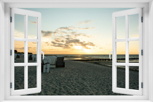Fototapeta Naklejka Na Ścianę Okno 3D - Sunset over the sea with beach chairs on the sandy beach