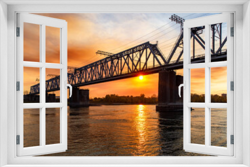 Fototapeta Naklejka Na Ścianę Okno 3D - First railway metal bridge over the great Siberian river Ob in Novosibirsk, stone pillars in the water, copy space, place for text, sunset sky