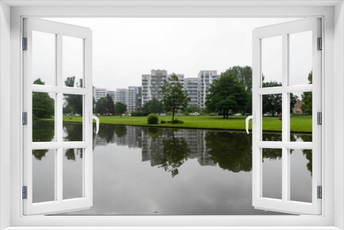 Fototapeta Naklejka Na Ścianę Okno 3D - Kortrijk, West Flanders Region - Belgium -  The Raemdonck city park water pond with residential apartment blocks reflecting in the background.