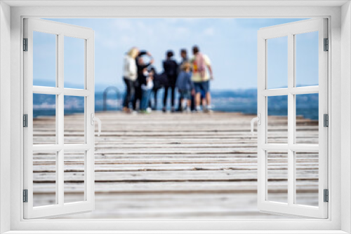 Fototapeta Naklejka Na Ścianę Okno 3D - People on a wooden pier pathway (soft focused background)