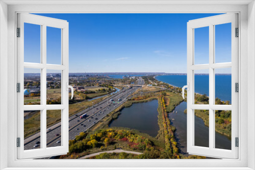 Fototapeta Naklejka Na Ścianę Okno 3D - Aerial view of the blue sea, lakes and a busy highway under the clear blue sky