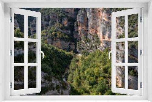 Fototapeta Naklejka Na Ścianę Okno 3D - rocky outcrops and caves that are home to Spanish Griffon vultures, Eurasion griffons (Gyps fulvus) in summer sunshine, Pyrenees mountains, Spain