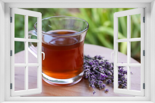 Fototapeta Naklejka Na Ścianę Okno 3D - Beautiful lavender flowers and cup of aromatic tea on wooden table, closeup