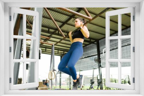 Athletic young woman exercising doing chin ups