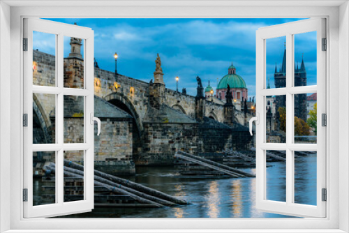 The historical Charles Bridge over Vltava river in Prague in blue hour in autumn. 