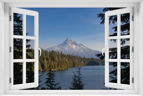 Fototapeta Naklejka Na Ścianę Okno 3D - Mt Hood rises in the distance over Lost Lake in Oregon mid-afternoon.  The blue lake and green pine trees from the majestic mountain. 