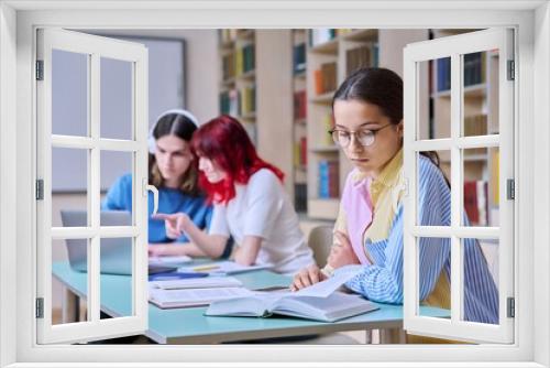 High school students studying in library class, teenage girl in focus