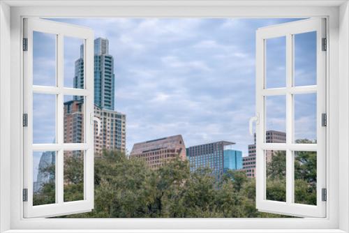 Fototapeta Naklejka Na Ścianę Okno 3D - Modern glass buildings behind thick lush green foliage in Austin Texas