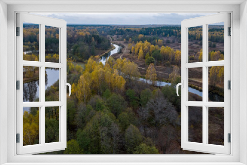 Fototapeta Naklejka Na Ścianę Okno 3D - panoramic view from a drone on the edge of the forest with wooden houses and a river against the backdrop of autumn nature