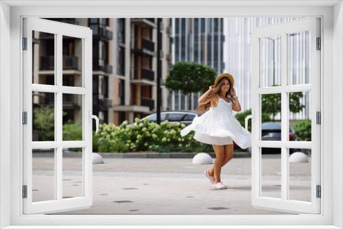 Beautiful pretty woman in white dress walking at city street