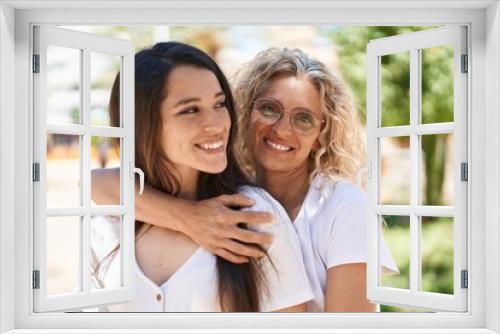 Two women mother and daughter hugging each other at park