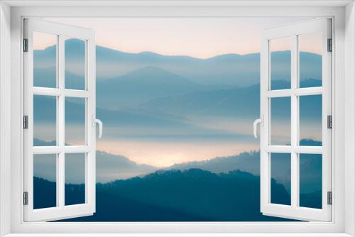 Fototapeta Naklejka Na Ścianę Okno 3D - A blue and orange glowing view of layers of mountains in the Smoky Mountains in North Carolina. There is a lot of haze and fog in the mountain valleys. 