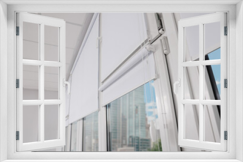 Fototapeta Naklejka Na Ścianę Okno 3D - Plastic windows with white roller blinds indoors