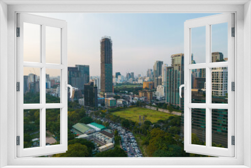 Aerial view modern office buildings and condominium park in Bangkok city downtown with sunset sky and clouds