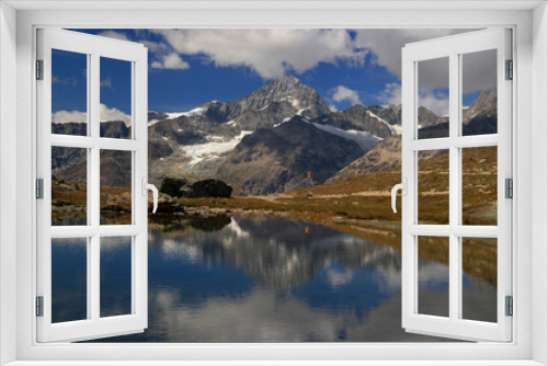 Fototapeta Naklejka Na Ścianę Okno 3D - A landscape with a smooth lake surface and mountains and clouds reflected in it, on a mountain Gornergrat, near Zermatt, in southern Switzerland