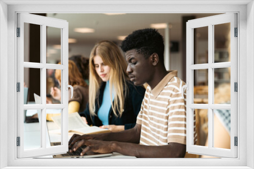 Young people studying together in university library - School education concept