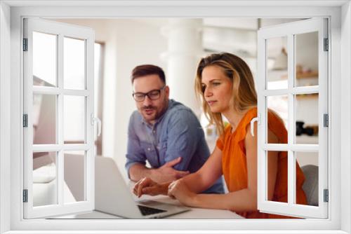 Happy couple doing business together working at small office