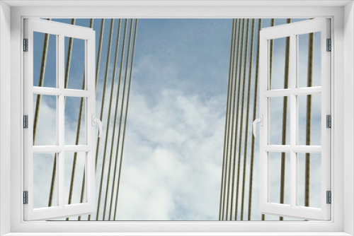 Fototapeta Naklejka Na Ścianę Okno 3D - Modern bridge cables against blue sky, low angle view