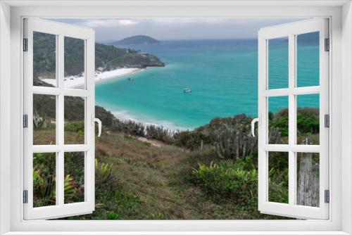 Fototapeta Naklejka Na Ścianę Okno 3D - Vista de cima da linda Praia Arraial do Cabo Atalaia, com suas areias brancas, um lindo mar em volta, muita vegetação ao redor e cercada de grandes montanhas verdes.
