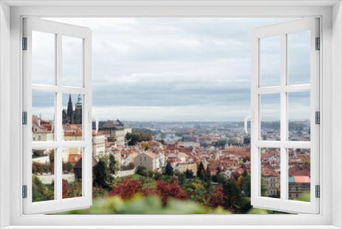 Fototapeta Naklejka Na Ścianę Okno 3D - View of Prague castle and orange roofs from a hill colored with red foliage