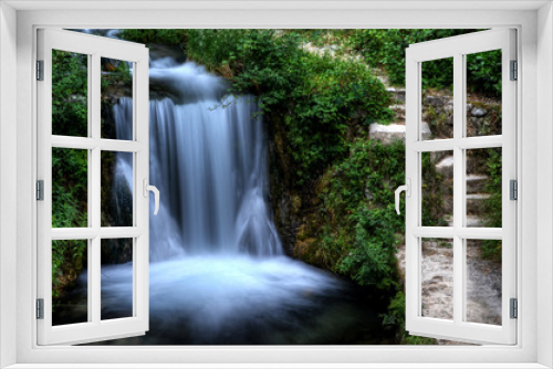 Fototapeta Naklejka Na Ścianę Okno 3D - Steps next to a waterfall in green garden
