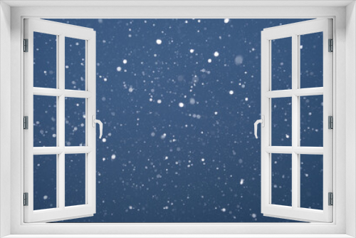Beautiful dark blue night background with falling snow. Texture of winter christmas holiday. Falling real snowflakes. Background with copy space for Christmas greeting cards or flyers design