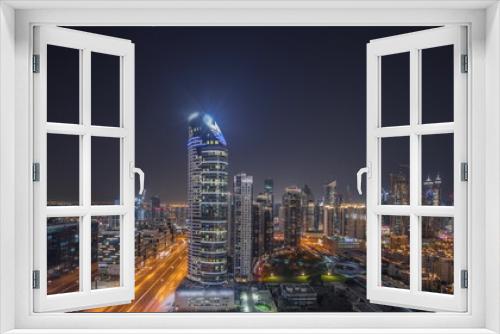 Fototapeta Naklejka Na Ścianę Okno 3D - Panorama showing Dubai's business bay towers aerial night timelapse. Rooftop view of some skyscrapers