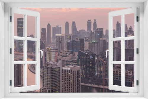Fototapeta Naklejka Na Ścianę Okno 3D - Skyline with modern architecture of Dubai business bay towers day to night timelapse. Aerial view