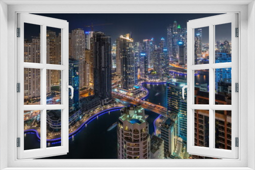 Fototapeta Naklejka Na Ścianę Okno 3D - Panorama showing various skyscrapers in tallest recidential block in Dubai Marina aerial night timelapse