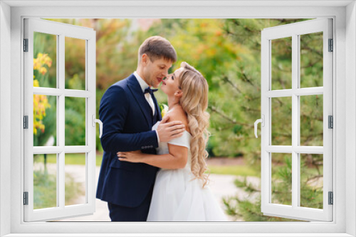 happy newlyweds. groom and bride in traditional wedding clothes kiss in park