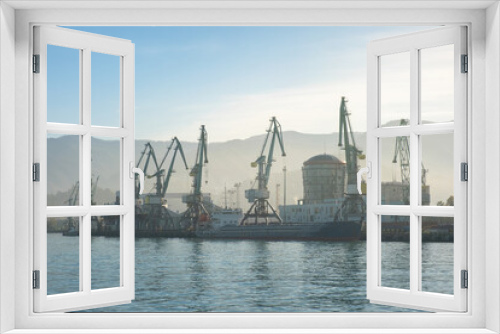 Fototapeta Naklejka Na Ścianę Okno 3D - Batumi sea port with cranes silhouettes, ships, ferries at sunrise. Logistic, industry, shipping, concept