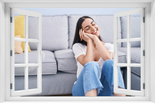 Young hispanic woman smiling confident sitting on floor at home