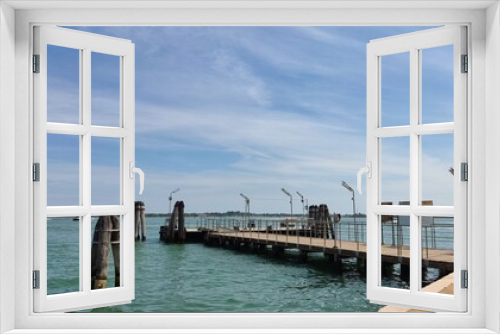 Fototapeta Naklejka Na Ścianę Okno 3D - Sea view, wooden bridge and pillars at the sea pier, Venice, Italy